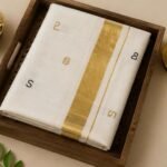 Premium Kerala Kasavu Cotton Saree with Gold Zari Border & Elegant Malayalam Letter Motifs